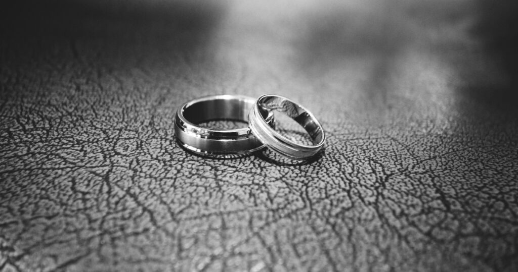 Two wedding rings on leather surface for a marriage that didn't work during midlife transformation.